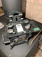Front view of Crescent cast iron toy stove with cookware on top