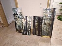 Four forest canvas prints leaning against wall
