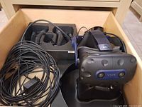 Drawer containing Vive headset, two controllers in foam cradle, long link cable and power adapter