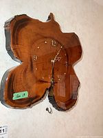 Front view of live edge wood slab wall clock showing numerals and hands