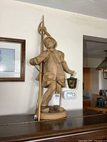 Full view of carved wood figure lamp on base