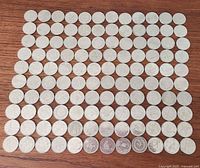 Grid view of all 120 quarters arranged 10×12 on wooden surface