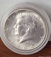 Obverse of 1964 Kennedy half dollar in capsule