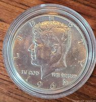 Obverse of 1964 Kennedy half dollar in capsule