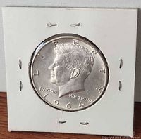 Full view of obverse side of 1964 Kennedy Half Dollar in flip