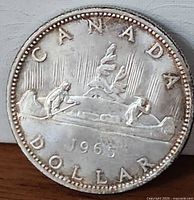 Reverse side of 1965 Canadian silver dollar showing voyageur design and date