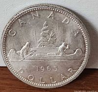 Reverse showing voyageur and Indigenous paddler in canoe with 1965 date