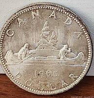 Reverse side showing CANADA, voyageur canoe design and 1965 date