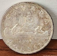 Reverse of 1965 Canadian silver dollar showing voyageur design