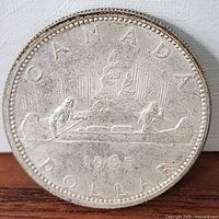 Reverse of 1965 Canadian silver dollar showing Voyageur canoe design
