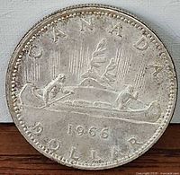 Reverse side of 1966 Canadian silver dollar showing Voyageur design and date