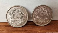 Front view of both 1957 Canadian 50-cent coins showing reverse coat of arms