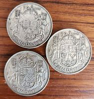 Three 1952 Canadian 50-cent coins reverse side showing coat of arms
