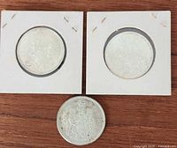 Group shot of three 1965 Canadian half dollars, two in holders one loose