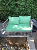 Front view of wicker loveseat with cushions