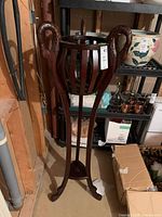 Full view of wooden slatted pedestal plant stand on three legs
