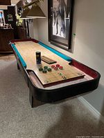 Full view of Fleetwood shuffleboard table with accessories on playing surface