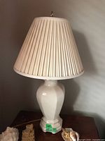 Full view of one lamp showing ceramic base and pleated shade