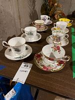 All eight teacup and saucer sets displayed