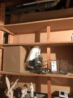 Pedestal vase on shelf beside boxed duplicate, decorative pine cones and acorns visible