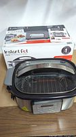Instant Pot Aura cooker with rack in front of original box