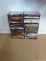 Full view of two tall stacks of horror DVDs on floor against wall