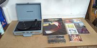 Entire lot: open Crosley turntable, vinyl record, seven CDs, three cassette tapes