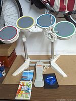 Full view of Rock Band drum kit with foot pedal and three Wii games
