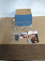 Overall lot showing decanter, two glasses, chillers, instruction card, Bespoke Post box