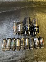 All thirteen vacuum tubes grouped on black surface