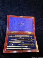 Open rosewood box showing all drafting instruments and blue interior