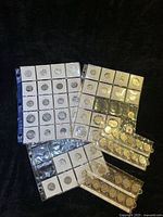 Group of album pages holding multiple rows of Canadian quarters in flips