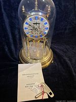 Clock under glass dome with instructions and key