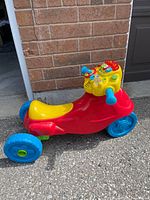 Side view showing full ride-on motorbike with three-wheel setup