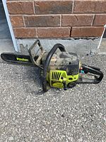 Left side view showing full chainsaw with bar and housing