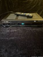 Front view of Rogers Nextbox Explorer 8642HD with remote on top, power indicator lit