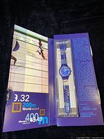 Fold-open display box showing watch and graphics of track records