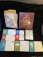 Group shot: album, loose stamps bag, envelopes, Centennial box