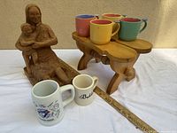 Group view of sculpture, footstool and all mugs