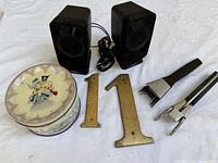 Full lot overview showing speakers, brass numbers, pot handles, decorative tin