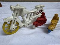 Three plastic motorcycles showing relative sizes and colours