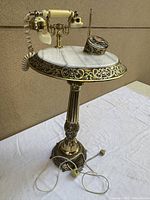 Full view of brass/marble pedestal telephone showing column and base