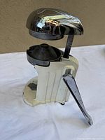 Front view of Rival Juice-O-Mat juicer showing chrome dome, lever, and ridged cone