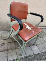 Front angled view of Interroyal metal armchair showing overall design and condition