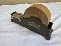 Full view of cast-iron tape dispenser with tape roll and Express Moistener label visible