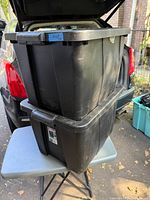 Two stacked black Sterilite totes with lids
