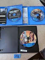 Open cases showing three PS4 game discs: Call of Duty: Black Ops 4, Battlefield 1, Grand Theft Auto V