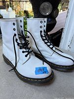 Full view of both white Dr. Martens boots showing uppers and laces