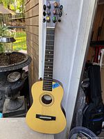 Full view of First Act Discovery acoustic guitar leaning against wall