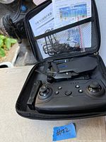Open case showing drone, controller, accessories and manual